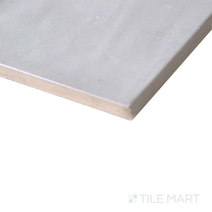 Diagonal view of Village Silver Mist 5x5 glossy ceramic tile, showcasing its soft silver-gray hue, sleek glossy texture, and structured square design.  