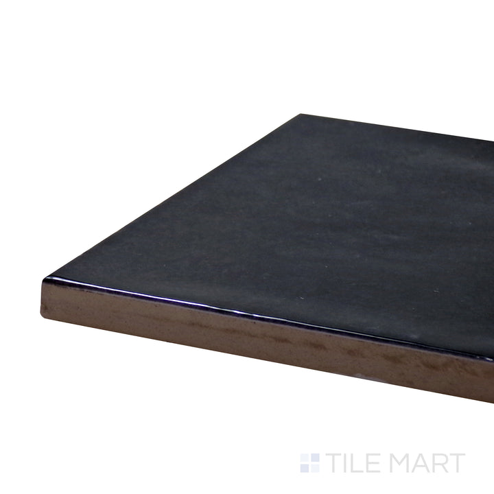 Angled close-up of Village Black 5X5 Glossy Ceramic Tile, showcasing its bold black hue with a modern, sleek glossy surface.