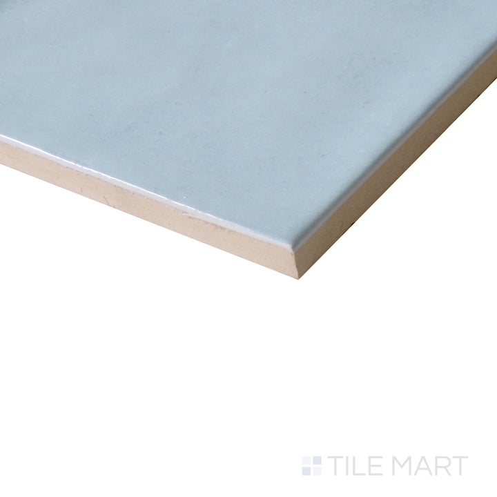 Diagonal view of Village Cloud 5x5 glossy ceramic tile, featuring a soft gray-blue tone, sleek finish, and contemporary square format.  