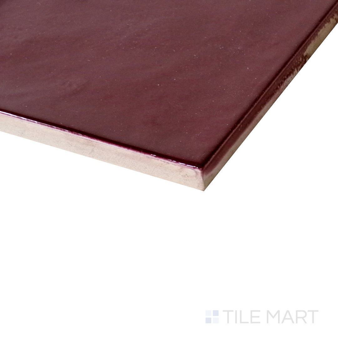 Angled shot of Village Aubergine 5x5 glossy ceramic tile, highlighting its deep purple tones, reflective glossy surface, and structured square format.  