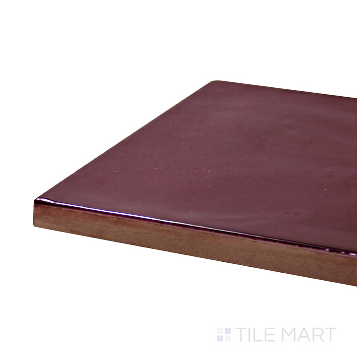 Angled view of Village Aubergine 5X5 Glossy Ceramic Tile, highlighting its deep purple tones with a sleek, reflective finish.
