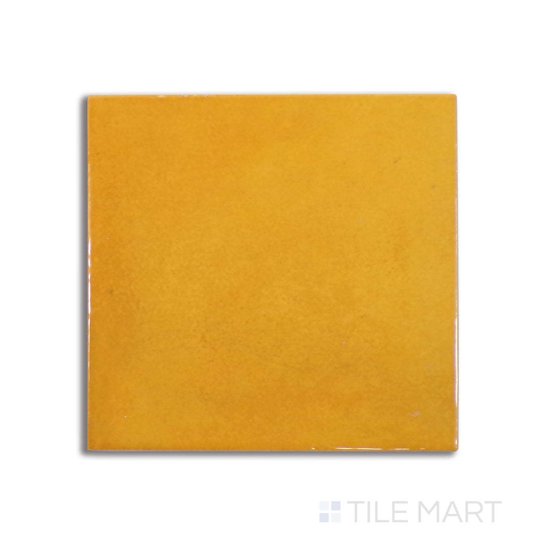Flat-lay image of Village Tuscany Gold 5X5 glossy ceramic tile, offering warm golden hues with a glossy texture that reflects natural light beautifully.