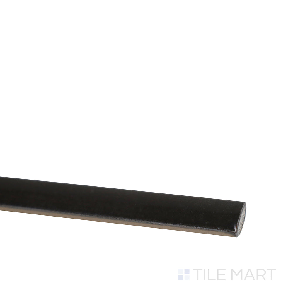 Diagonal view of Village Black 0.5x8 glossy ceramic jolly tile, showcasing its sleek black shade, reflective surface, and slim rectangular format.  