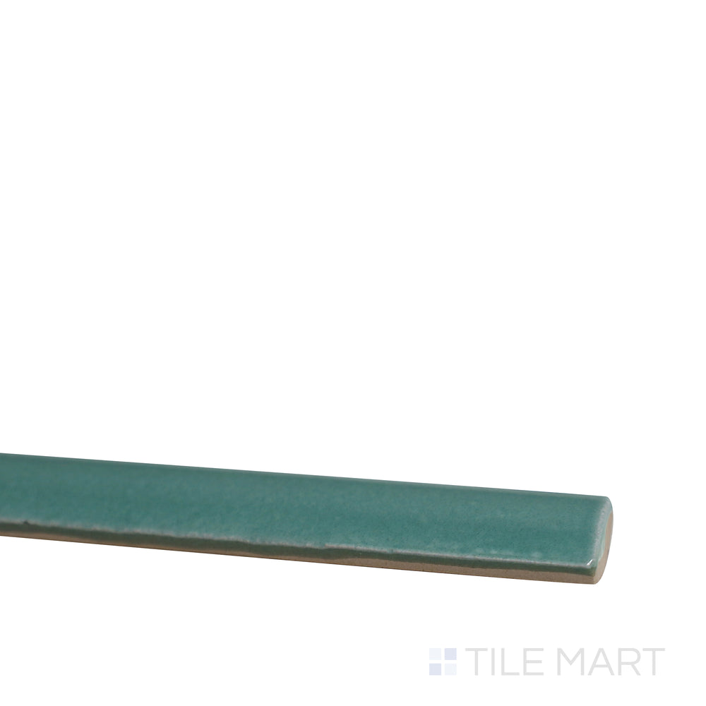 Angled view of Village Emerald Green 0.5x8 glossy ceramic jolly tile, featuring a luxurious green shade, polished finish, and elegant trim style.  
