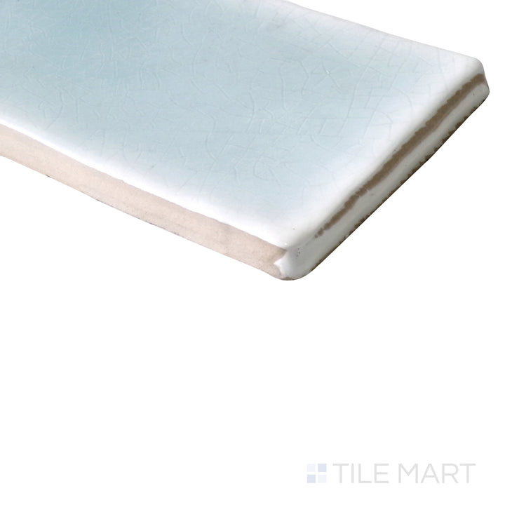 Angled shot of Vitral Aqua 3x12 glossy ceramic tile, featuring a vibrant aqua blue shade, sleek glossy surface, and an elongated rectangular design.  