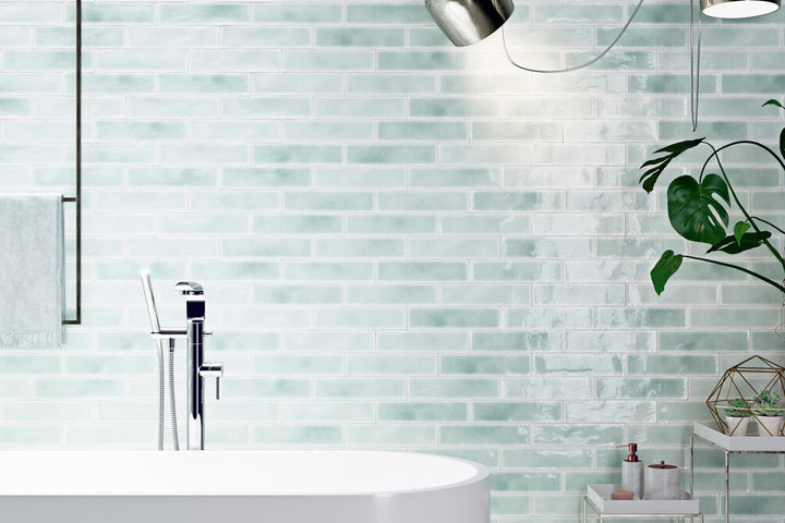A vibrant and refreshing interior featuring Vitral Aqua 3X12 Glossy Ceramic, with its deep blue-green tones and polished surface creating a sleek, modern ambiance.