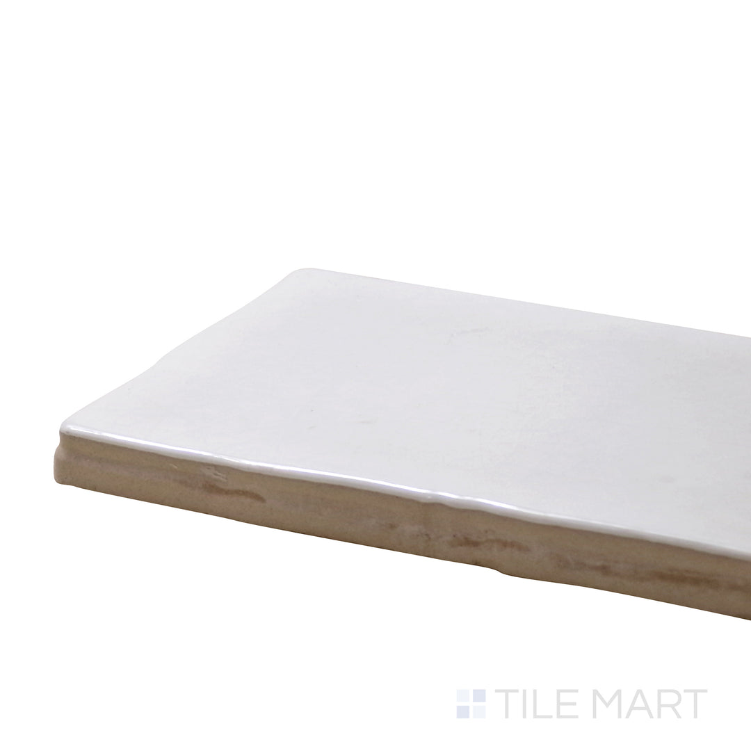 Angled view of Vitral Bianco 3X12 Glossy Ceramic Tile, highlighting its crisp white tones with a reflective, polished surface.