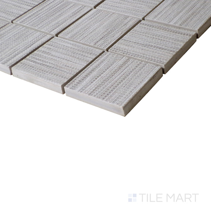Angled shot of Wooow Linen Cotton 2" square matte porcelain mosaic, featuring soft off-white hues, a linen-textured surface, and structured square format.  