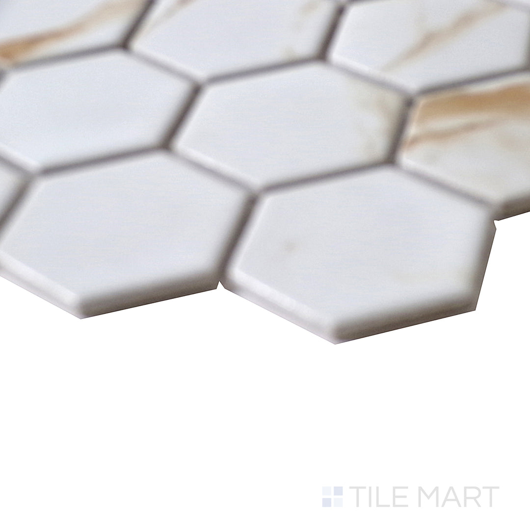 Angled shot of Porcelain Glazed Mosaics Calacatta Gold 2" square matte tile, featuring a luxurious white background, warm golden veins, and a sophisticated matte finish.  
