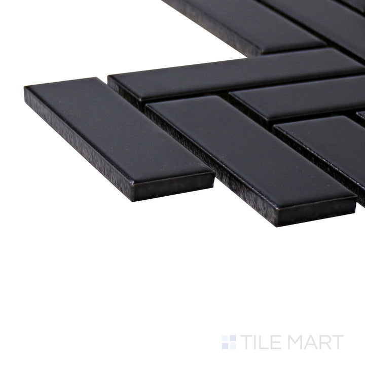 Angled close-up of Porcelain Glazed Mosaics Black Herringbone Matte Tile, showcasing its bold black tones with a contemporary herringbone layout and a soft matte texture.