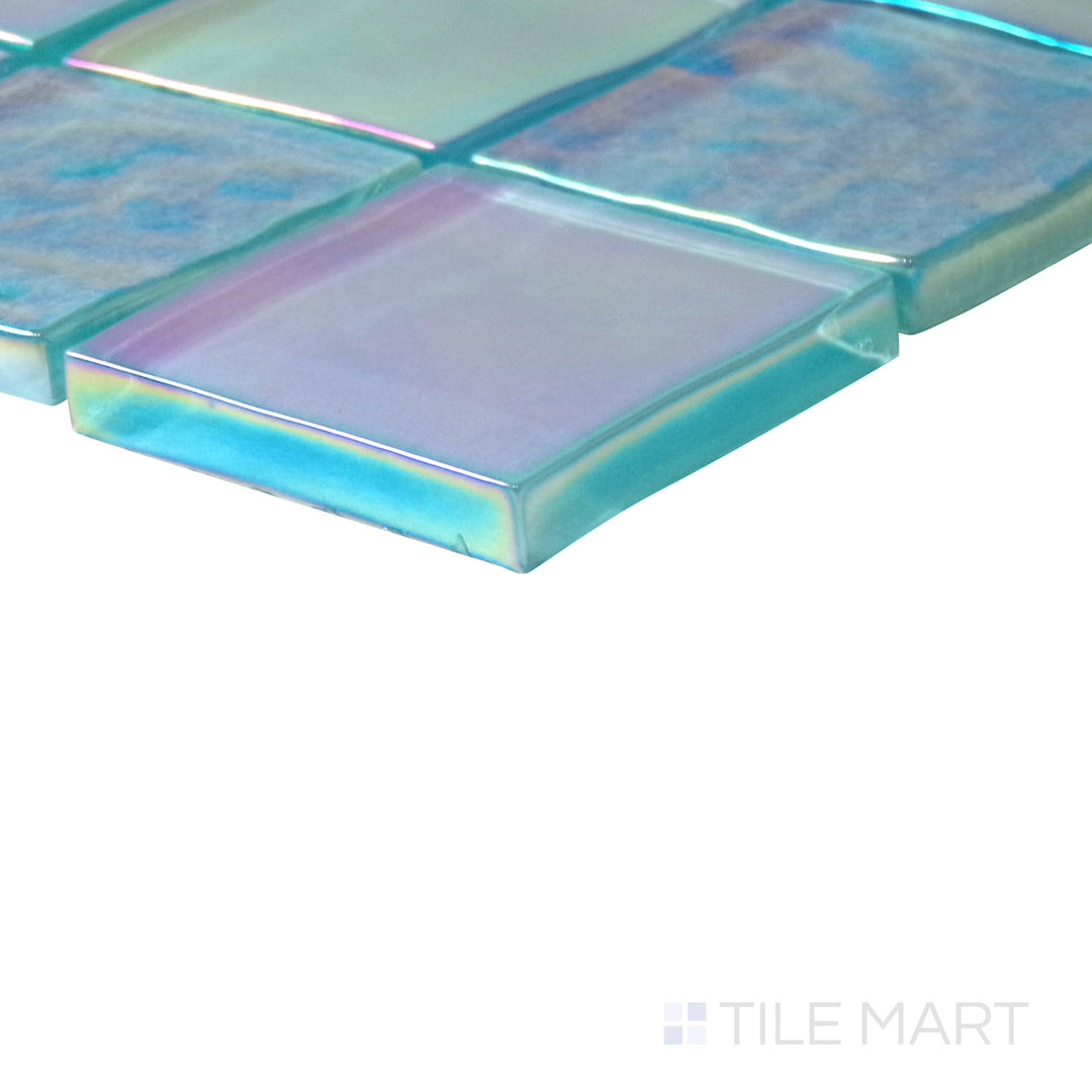 Slanted perspective of Vidrofina Aguamarina 2" square glossy glass mosaic, emphasizing its vibrant aquamarine blue shades, glossy polished finish, and modern square pattern.  