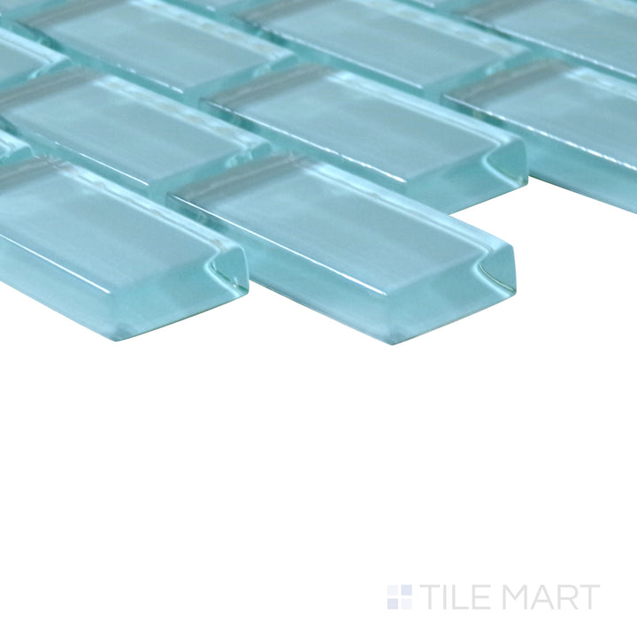 Diagonal view of Vidrofina Larimar Green brick glossy glass mosaic, showcasing its rich green shades, reflective glossy surface, and contemporary brick pattern.  