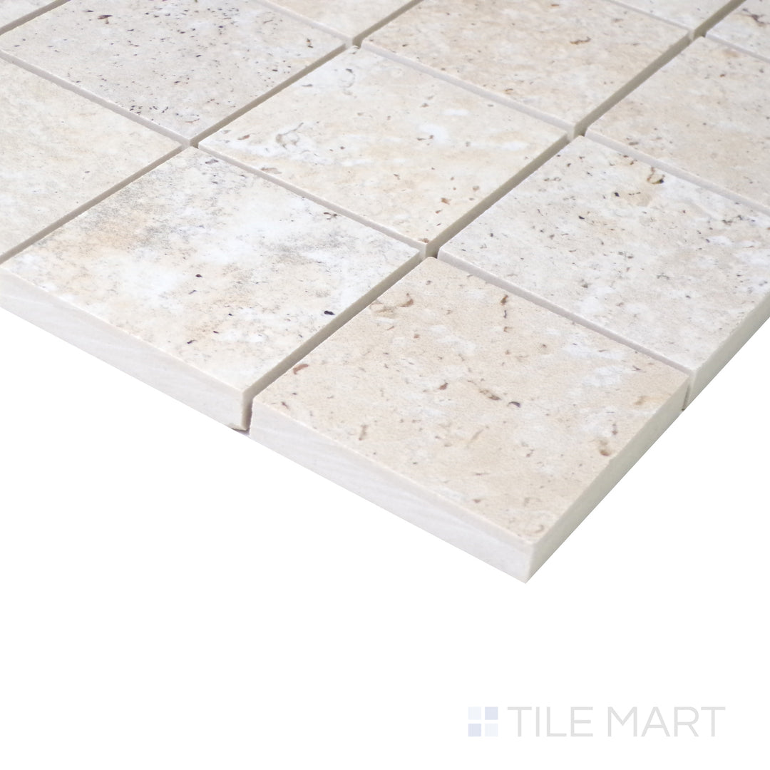 Angled shot of Astrum Ivory 2" square matte porcelain mosaic, featuring warm ivory hues, a smooth matte texture, and a geometric square arrangement.  