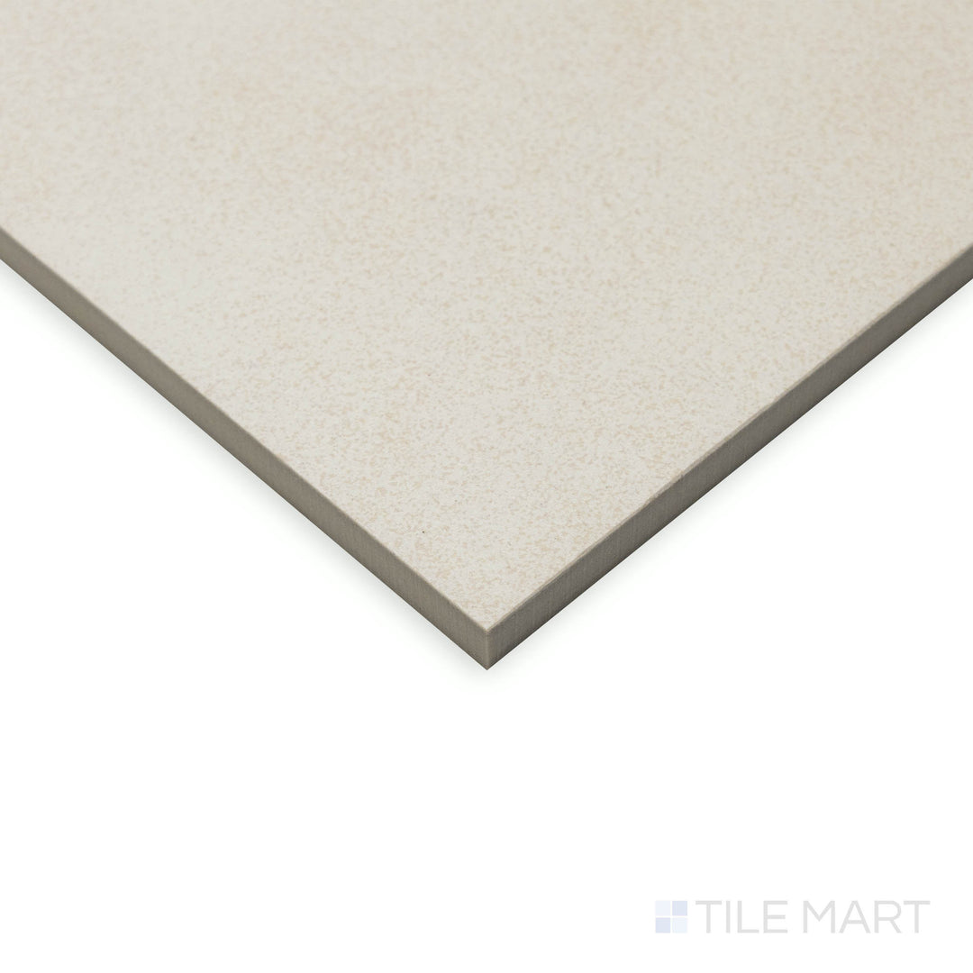 At an angled view, the Crush White 48x48 matte porcelain tile presents a vast surface with a soft, muted finish, meeting at sharp, well-defined edges.