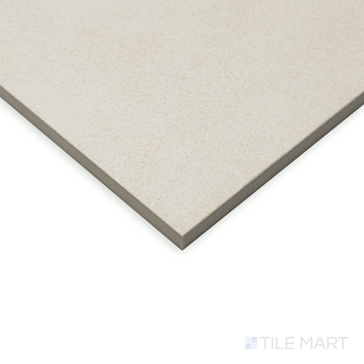 At an angled view, the Crush White 48x48 matte porcelain tile presents a vast surface with a soft, muted finish, meeting at sharp, well-defined edges.