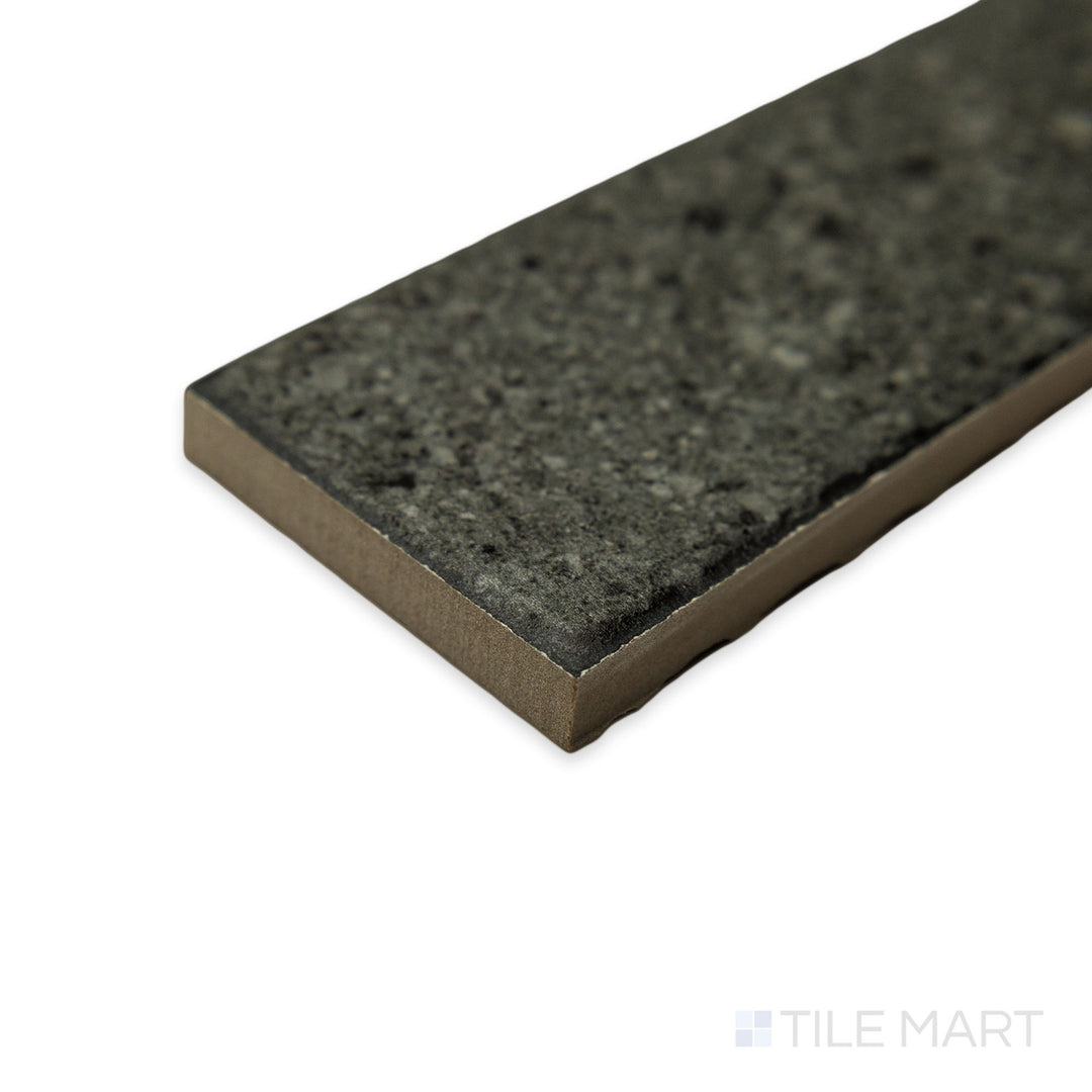 Viewed at a sharp angle, the Block Dark 2x8 matte porcelain tile displays an intense charcoal depth, where two edges form a clean, uninterrupted meeting point.