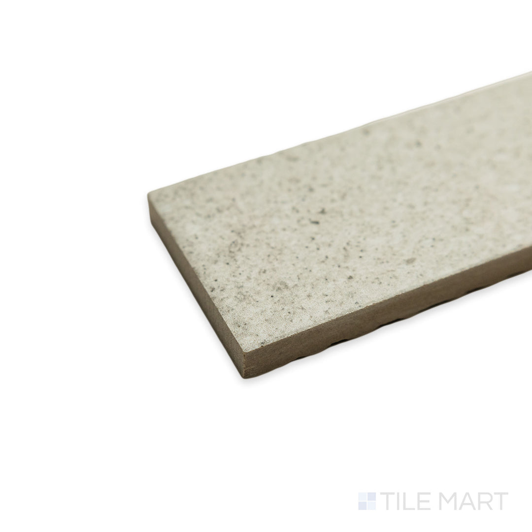 A close-up corner view of the Block Pearl 2x8 matte porcelain tile reveals its elegant neutral hue, with light gently fading along its smooth transition between planes.