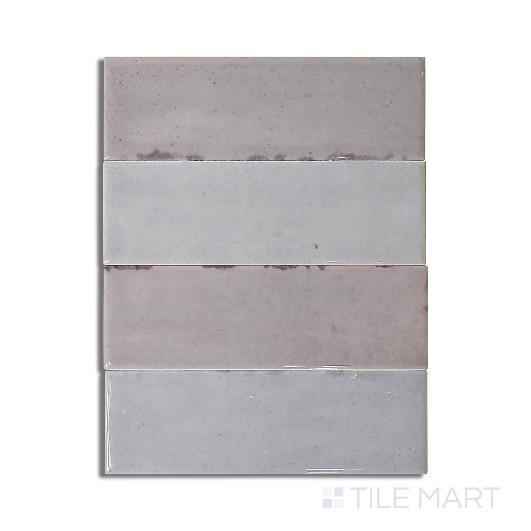 Flat-lay of Calpe Greige 2X6 Glossy Porcelain, a sophisticated greige-toned tile with a reflective surface, blending neutral elegance and shine.