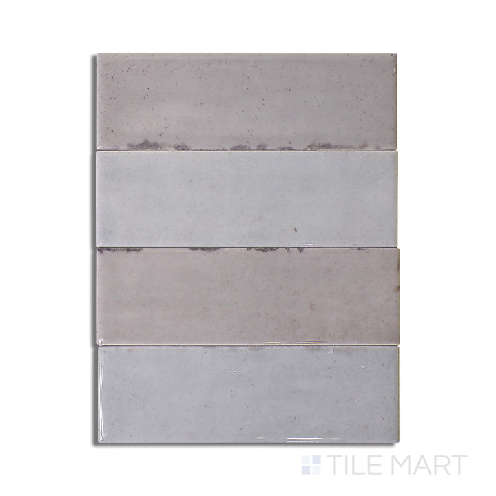 Flat-lay of Calpe Greige 2X6 Glossy Porcelain, a sophisticated greige-toned tile with a reflective surface, blending neutral elegance and shine.