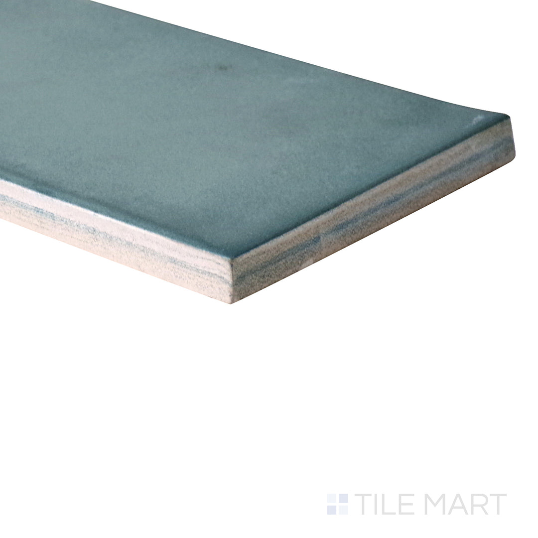 Slanted perspective of Ghent Smokey Emerald 3x9 matte porcelain tile, emphasizing its deep emerald green tones, subtle matte finish, and structured rectangular layout.  