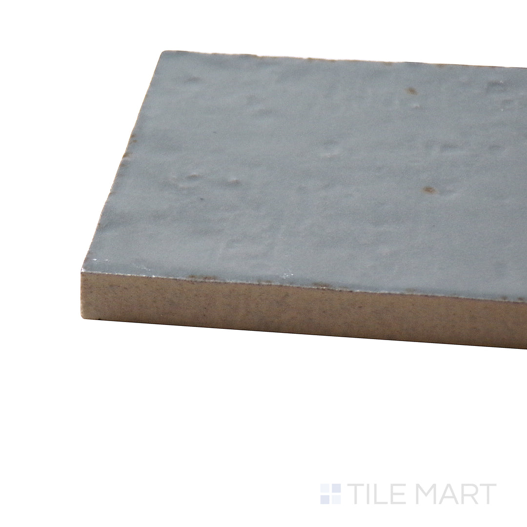 Corner shot of Glace Avio 3X8 Glossy Porcelain Tile, showcasing its soft blue-gray tones with a high-gloss, polished surface.