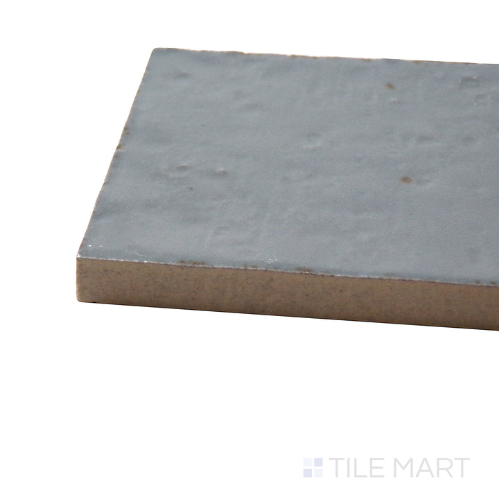 Corner shot of Glace Avio 3X8 Glossy Porcelain Tile, showcasing its soft blue-gray tones with a high-gloss, polished surface.