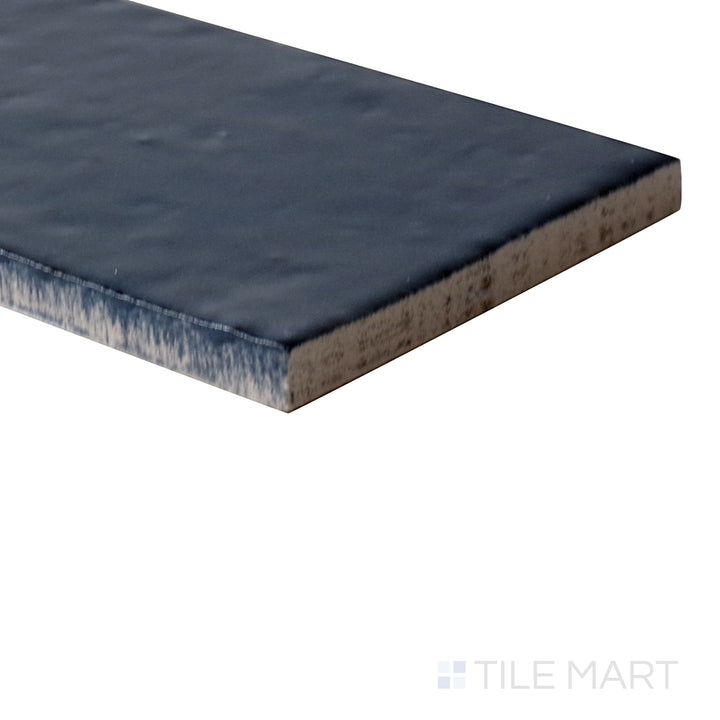 Angled shot of Glace Blu Notte 3x8 glossy porcelain tile, featuring a deep navy blue shade, sleek polished finish, and structured rectangular layout.  