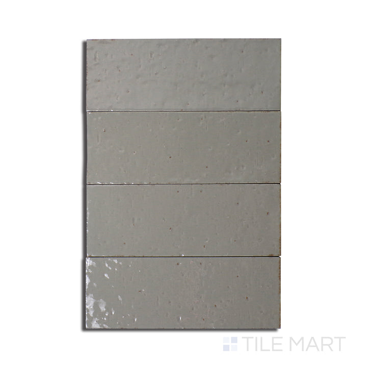 Flat-lay of Glace Muschio 3X8 Glossy Porcelain, a muted green tile with a high-shine glossy surface, creating a modern and organic look.