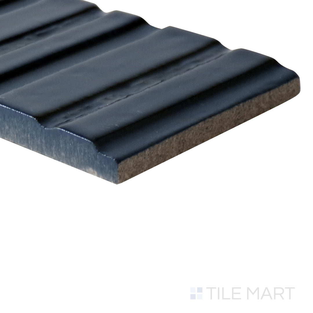 Angled shot of Glace Blu Notte 3x8 glossy porcelain tile, featuring a deep navy blue shade, high-gloss finish, and an elongated rectangular format.  