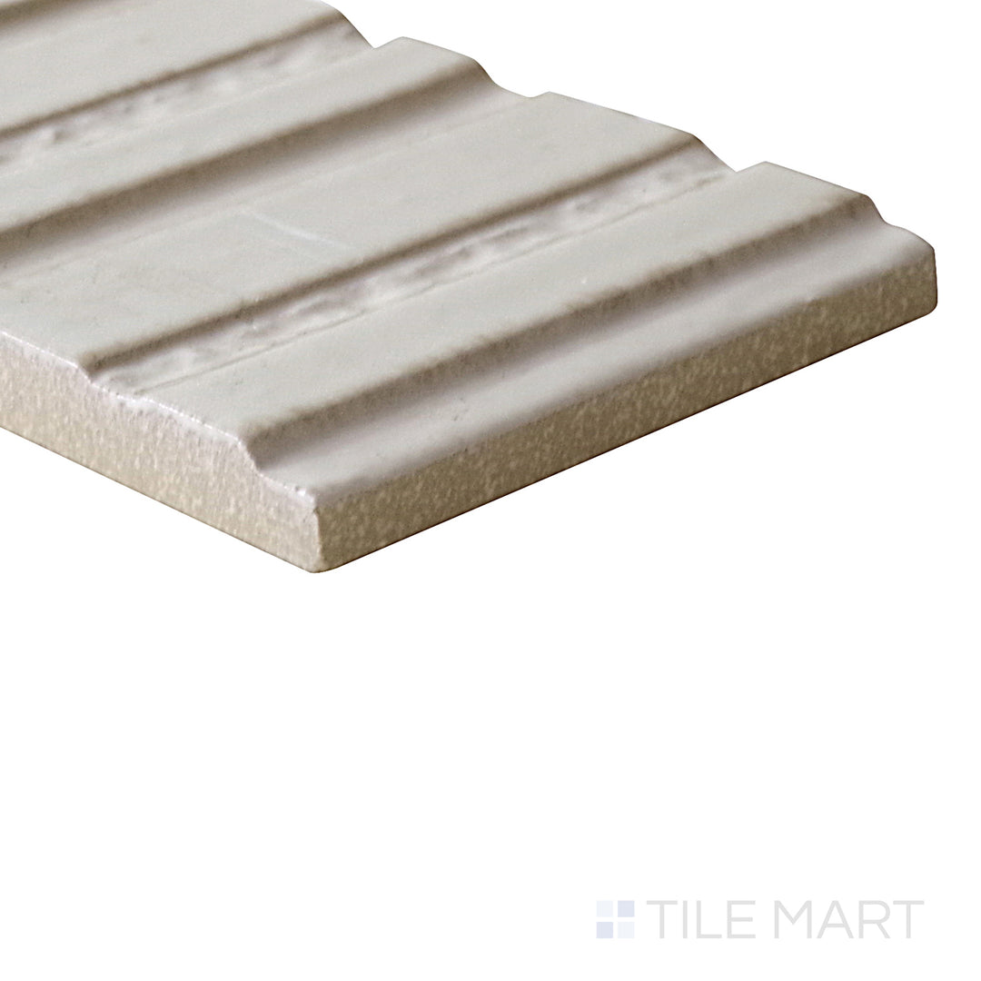 Diagonal view of Glace Mastice 3x8 glossy porcelain tile, showcasing its soft gray tones, reflective glossy surface, and structured rectangular design.  