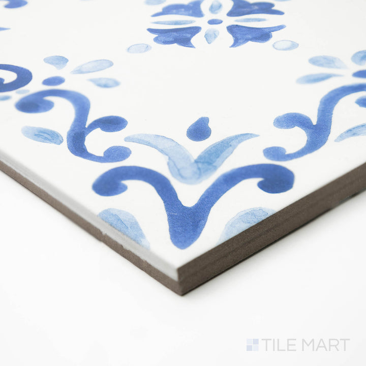 Side-corner view of Mestral Garden 9x9 matte porcelain tile, highlighting its intricate design, muted color tones, and the carefully shaped intersection of edges.