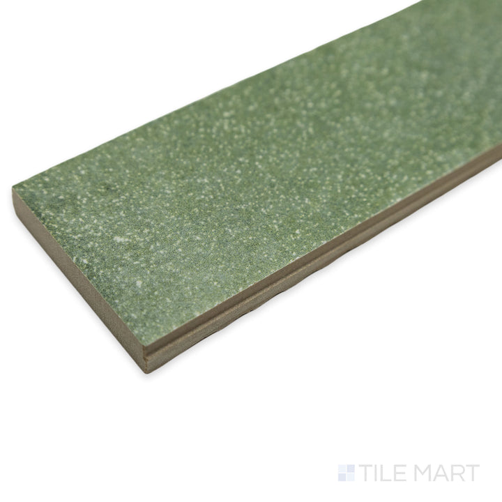 Close-up corner shot of Tetris Muschio 2x8 matte porcelain tile, drawing attention to its muted green tone, structured format, and the crisp meeting of its edges.