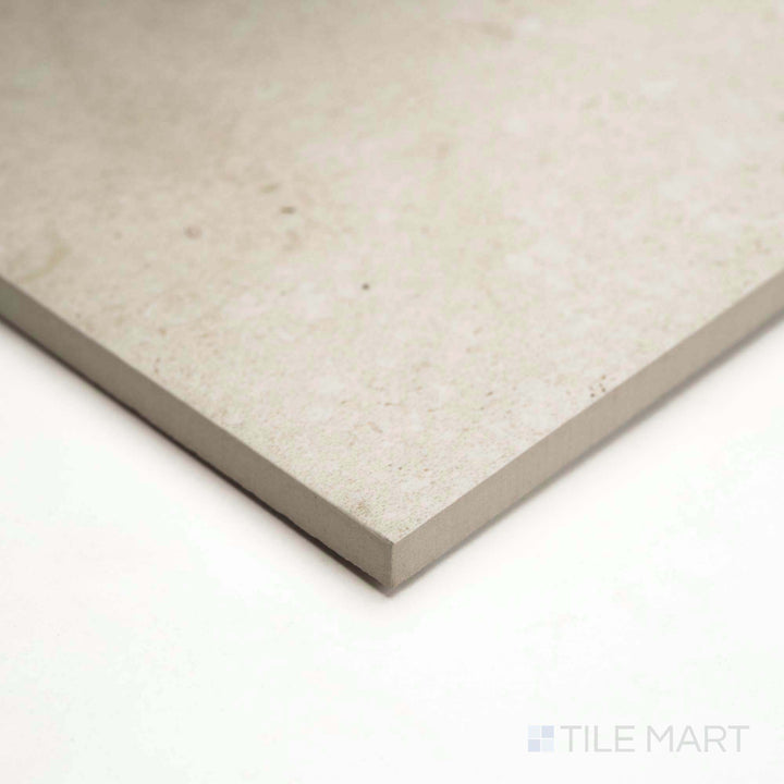 A corner shot of Pietra Coral Natural 24x48 matte porcelain tile reveals its earthy tones and stone detail.