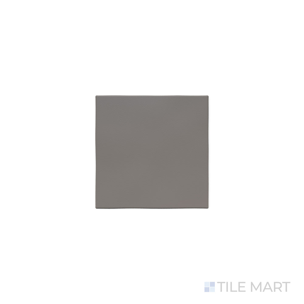 The deep gray hue of Quarry + Gray 6x6 matte ceramic tile is accentuated in this close-up shot, emphasizing its smooth matte texture and versatile modern style.