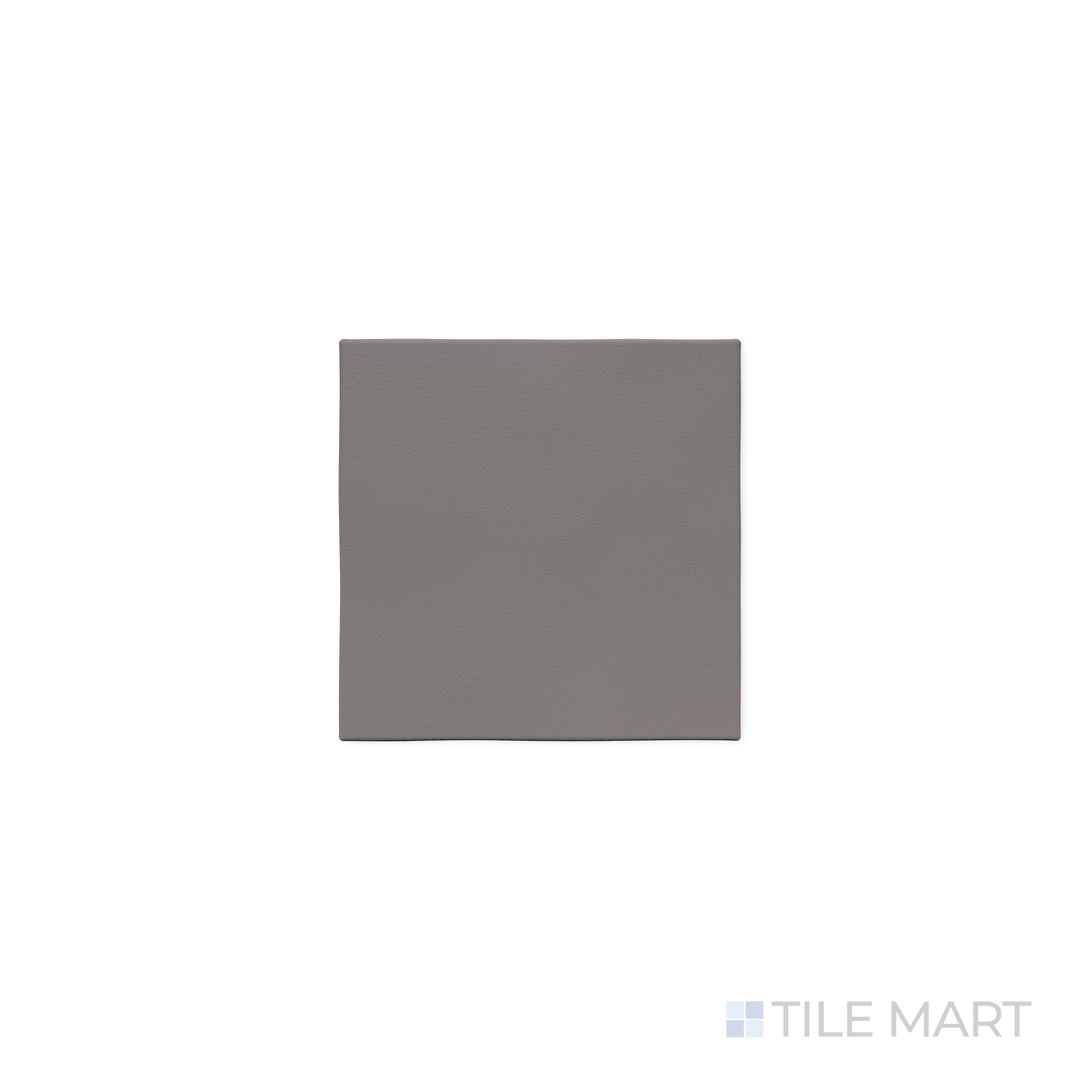 The deep gray hue of Quarry + Gray 6x6 matte ceramic tile is accentuated in this close-up shot, emphasizing its smooth matte texture and versatile modern style.