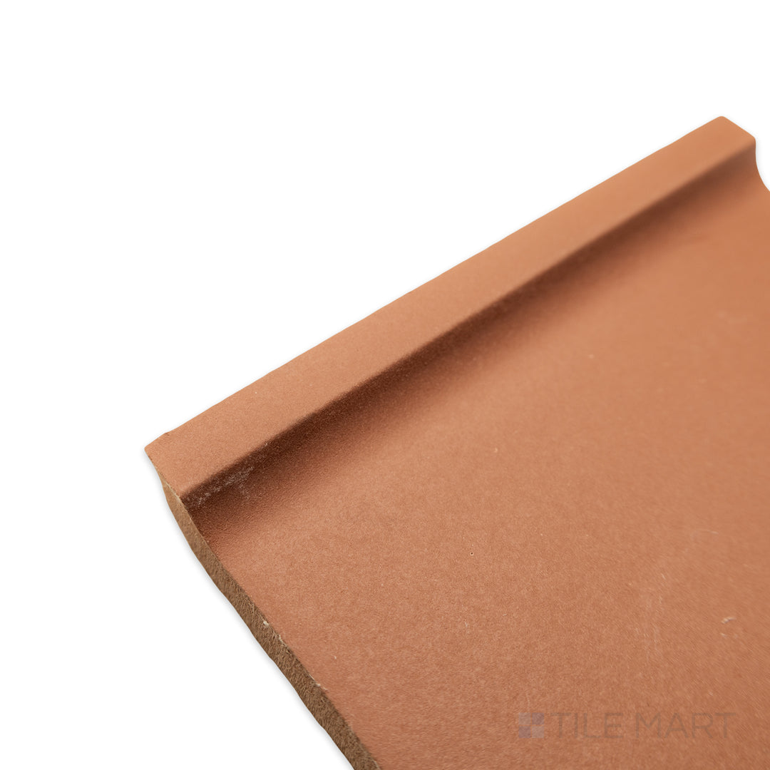 Angled corner shot of Quarry + Red 6x6 matte ceramic cove base, featuring a deep red tone with a curved edge and a smooth matte finish.