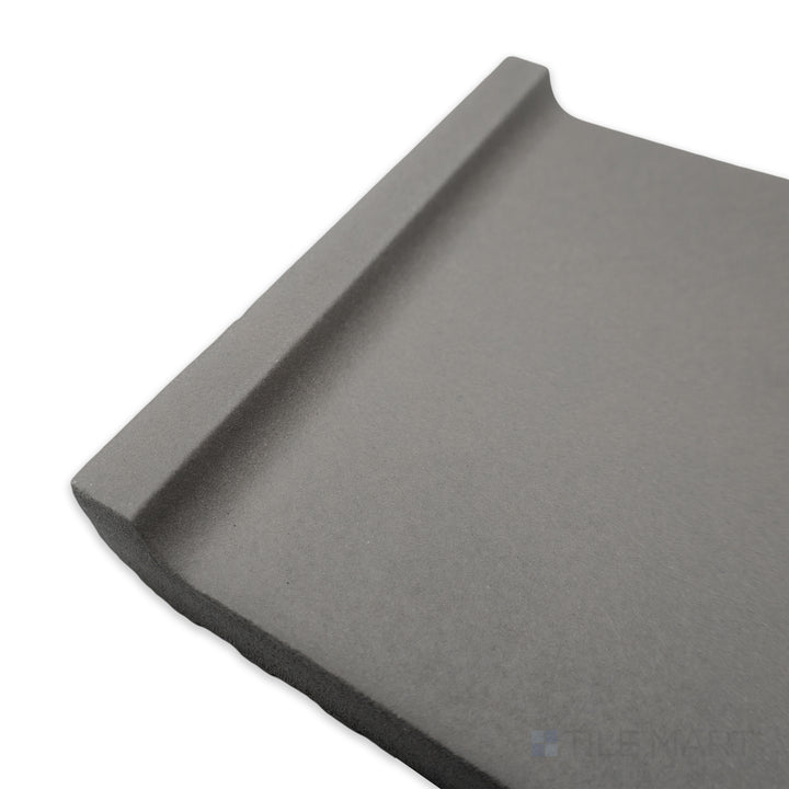 Corner perspective of Quarry + Gray 6x6 matte ceramic cove base, highlighting its soft grey tone with a rounded edge and refined matte texture.