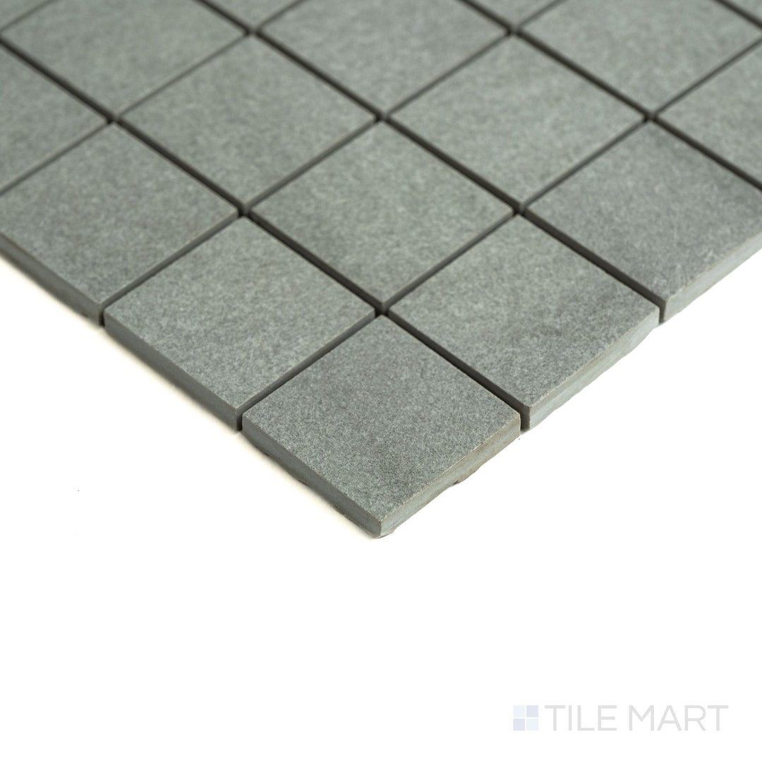 Angled perspective shows off Origin Canyon 2" squares in earthy shades, arranged in a refined matte porcelain grid.