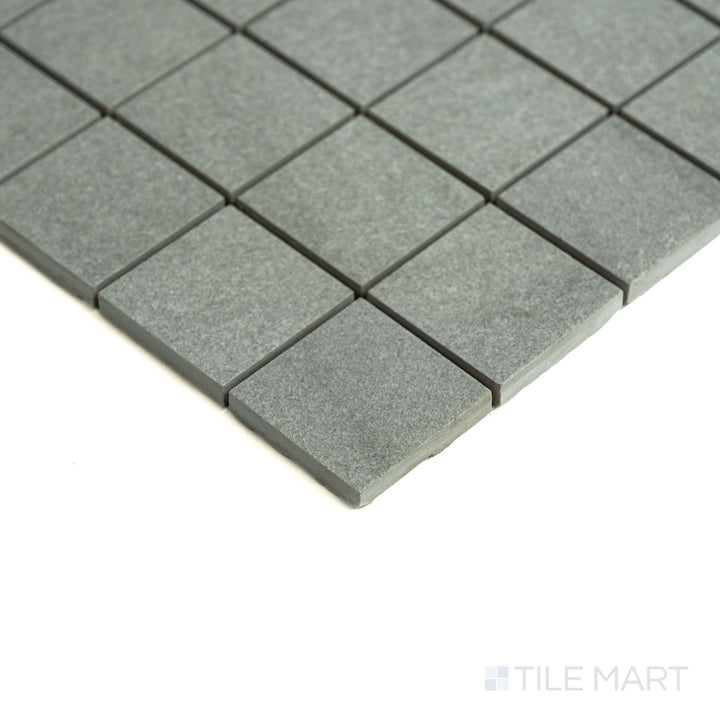 Angled perspective shows off Origin Canyon 2" squares in earthy shades, arranged in a refined matte porcelain grid.