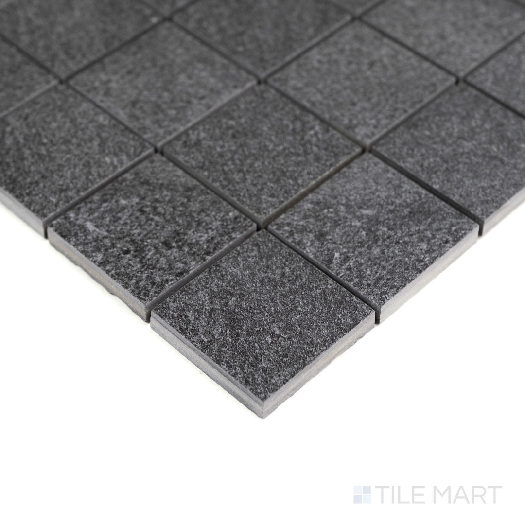 From the corner, Origin Boulder 2" mosaic tiles display cool gray tones and subtle texture in a structured matte pattern.