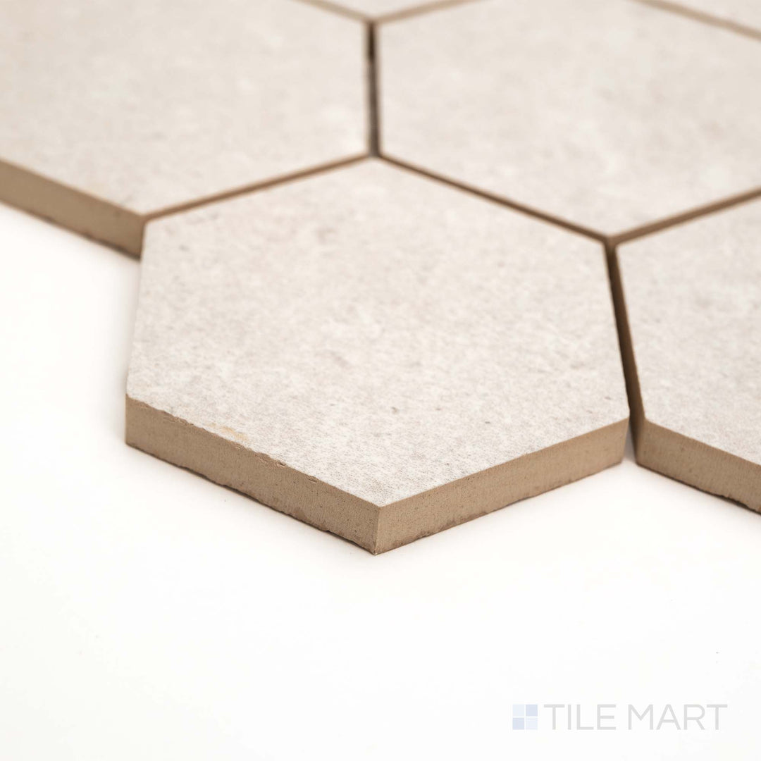 Pietra Coral Pearl 3" Hexagon matte mosaic is presented at an angle, emphasizing its soft hues and bold geometry.