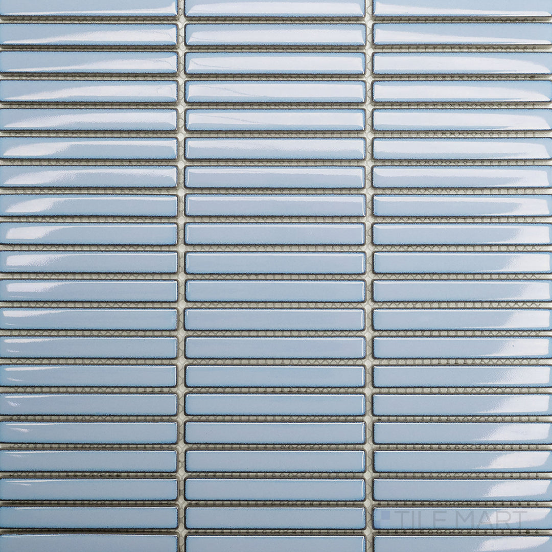 Flat-lay of Porcelain Glazed Mosaics Aged Sky Blue Mini Sticks Glossy, a soft blue mosaic tile with a glossy surface and subtle aged detailing.