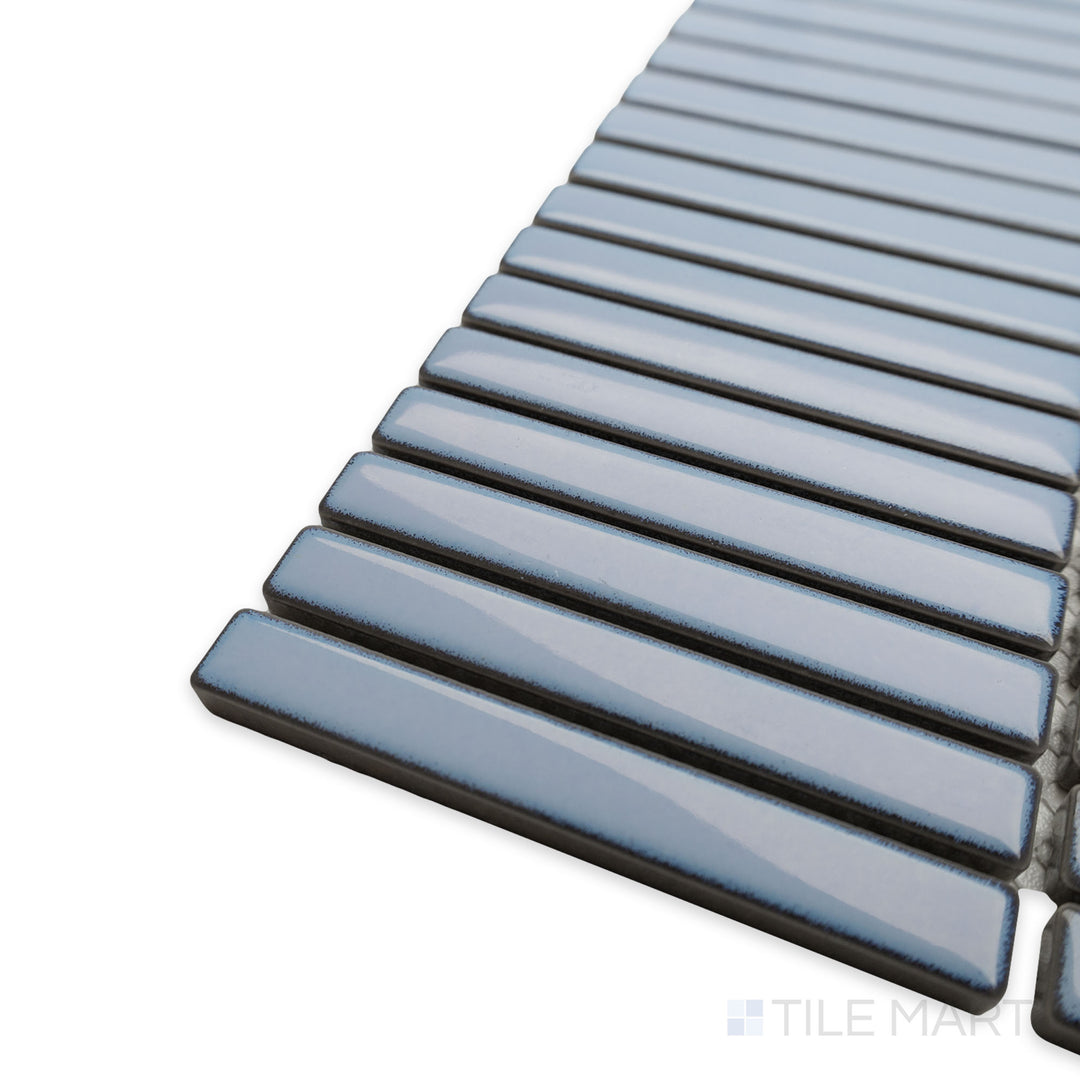 Corner-focused image of Porcelain Glazed Mosaics Aged Sky Blue Mini Sticks Glossy tile, drawing attention to its luminous finish, sleek vertical pattern, and how its edges align at a perfect angle.