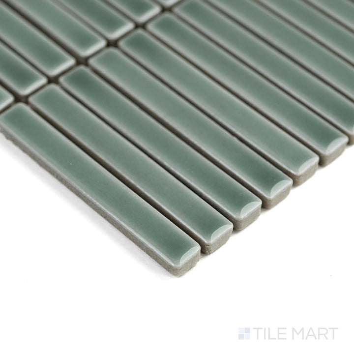 Aged Grey Mini Sticks porcelain mosaic in a glossy finish reflects light beautifully in this angled corner view.