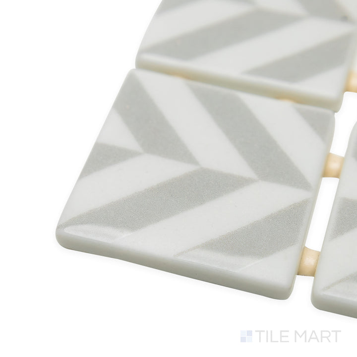 Angled shot of Onix Glass Icon Light Grey 2" square Chevron matte gloss mosaic, drawing attention to its cool grey hue, structured corner definition, and balanced matte-gloss contrast.