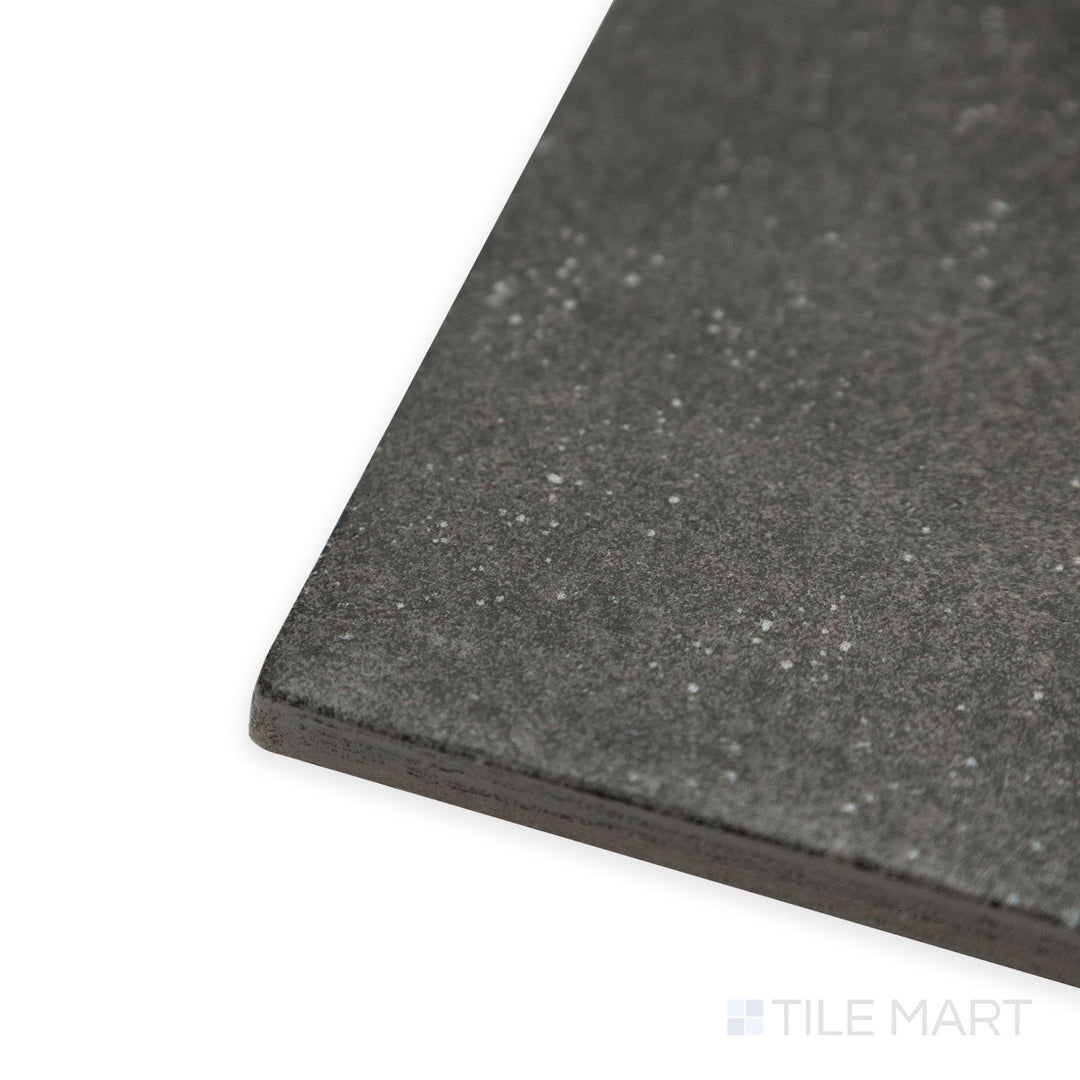 Angled close-up of Stage Charcoal 4x4 matte porcelain tile, emphasizing its deep charcoal shade, matte finish, and sharp corner transition.