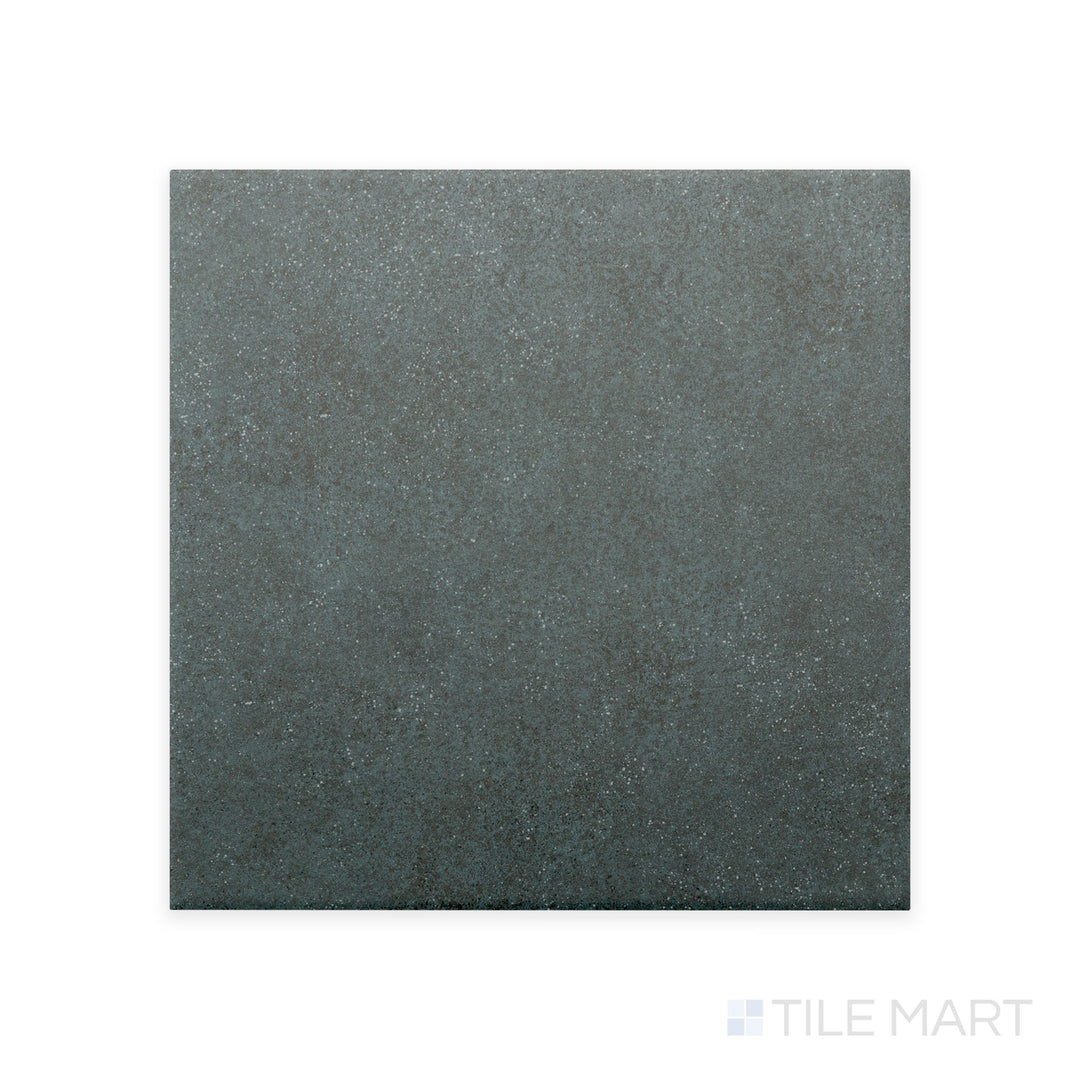 A detailed close-up of Stage Denim 4X4 matte porcelain tile captures its muted blue hue and velvety matte texture, adding a subtle pop of color to contemporary designs.