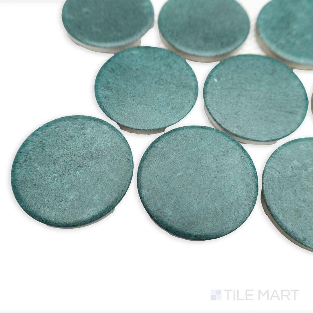 Stage Denim 2" penny round matte porcelain mosaic tile seen from a corner perspective, with cool blue tones and visible rounded tile edges.