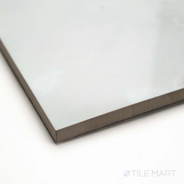 Angled view of Soller Onyx Blanco 24x48 polished porcelain tile, featuring reflective white surface, subtle veining, and a clean tile edge profile.