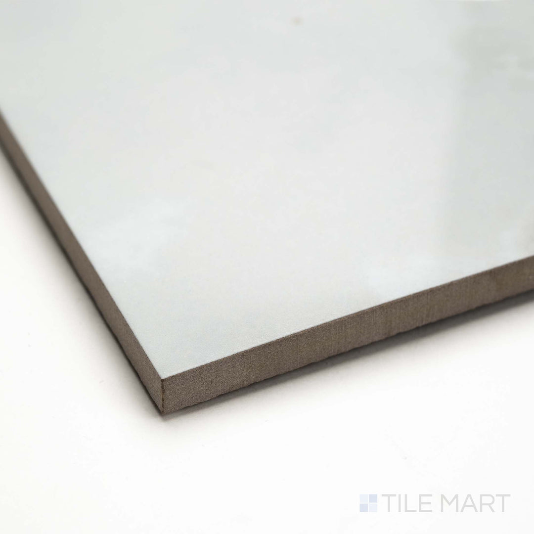 Angled view of Soller Onyx Blanco 24x48 polished porcelain tile, featuring reflective white surface, subtle veining, and a clean tile edge profile.